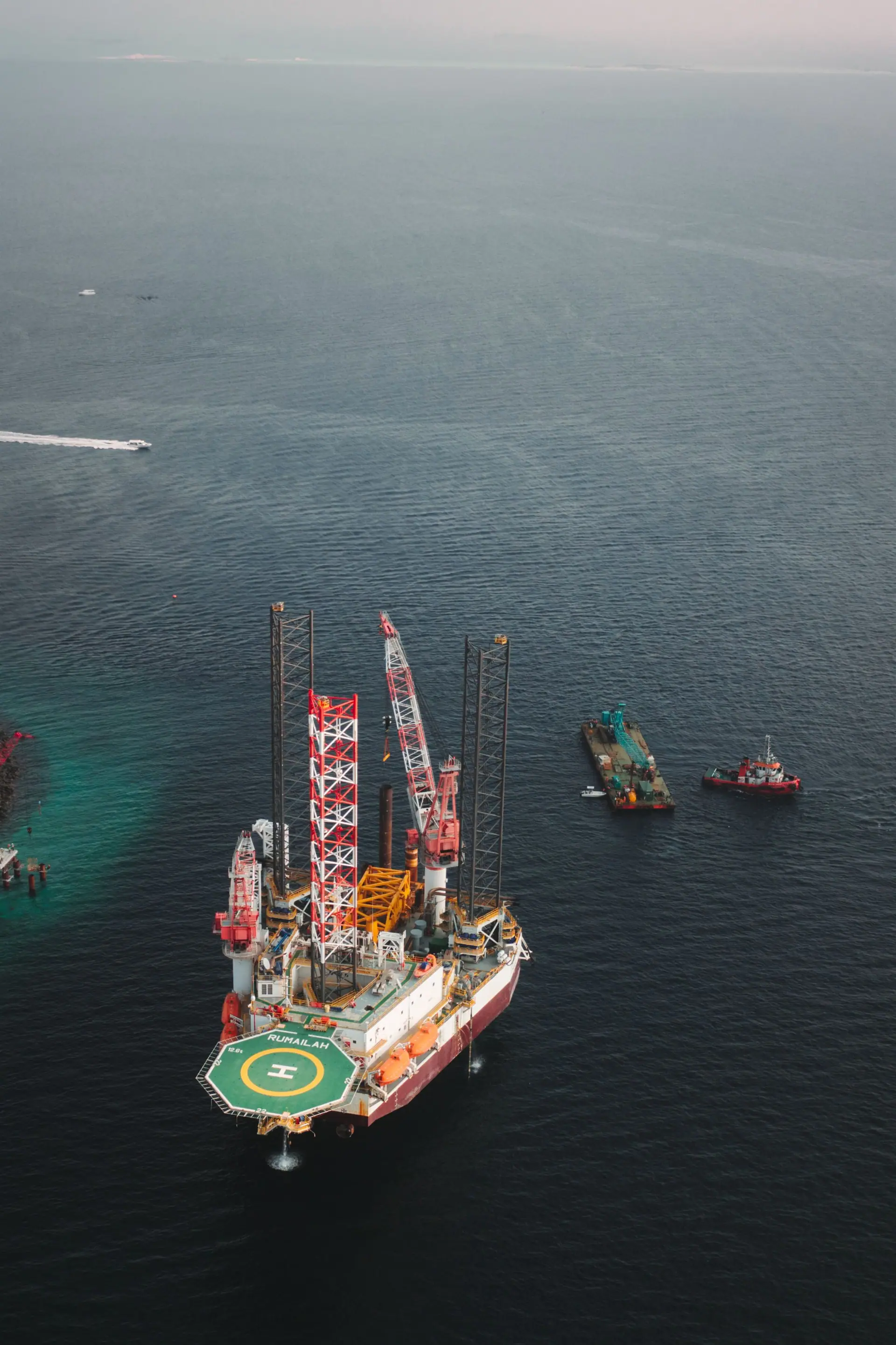Offshore drilling platform with support vessels working alongside at sea.